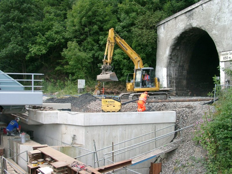 Verschiebung der neuen Eisenbahn Brcke in Freienohl. Komatsu Bagger beim begradigen des Schotters vor dem Freienohler Tunnel.