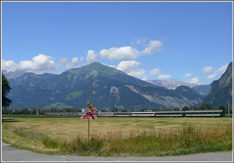 Vor der Kulisse des Vilan und der Scesaplana fhrt eine Re 460 mit einem IR Richtung Landquart. Wander-und Fahrradwegkreuzung in der Ebene bei Zizers. (09.07.2008)