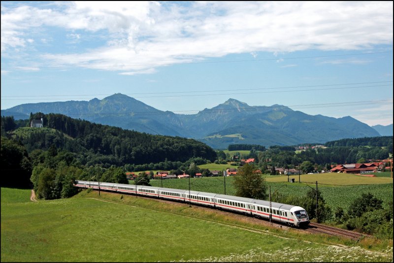 Vor der Kullisse der Chiemgauer Berge ist der InterCity 2293 auf dem Weg von Saarbrcken Hbf nach Salzburg Hbf. Hier bei Vachendorf braucht der Zug noch ca. 25 Minuten bis zum Ziel. (06.07.2008)
